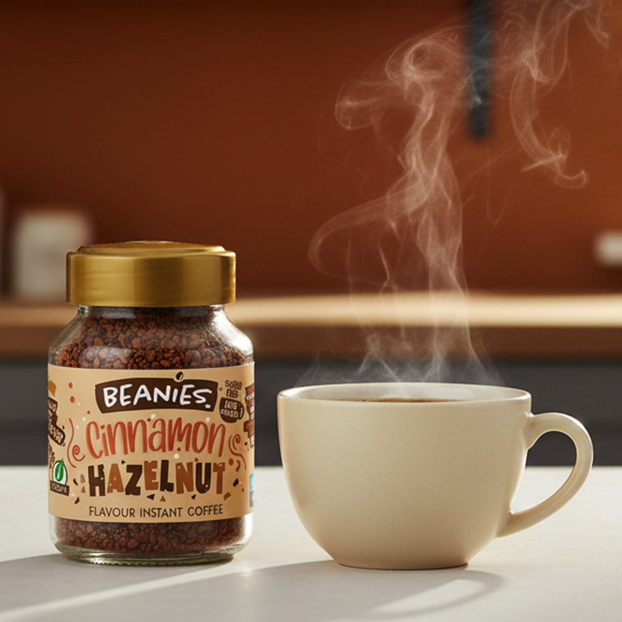 Jar of Beanies Cinnamon Hazelnut instant coffee next to a steaming cup on a table.