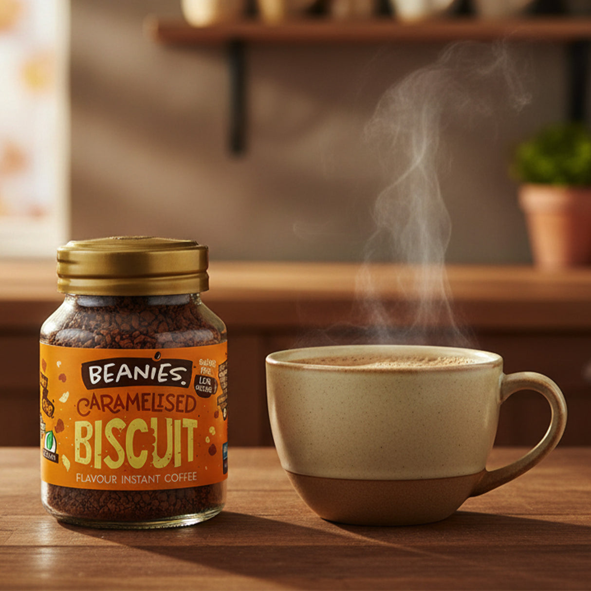 Jar of Beanies caramelised biscuit instant coffee next to a steaming cup on a wooden surface.
