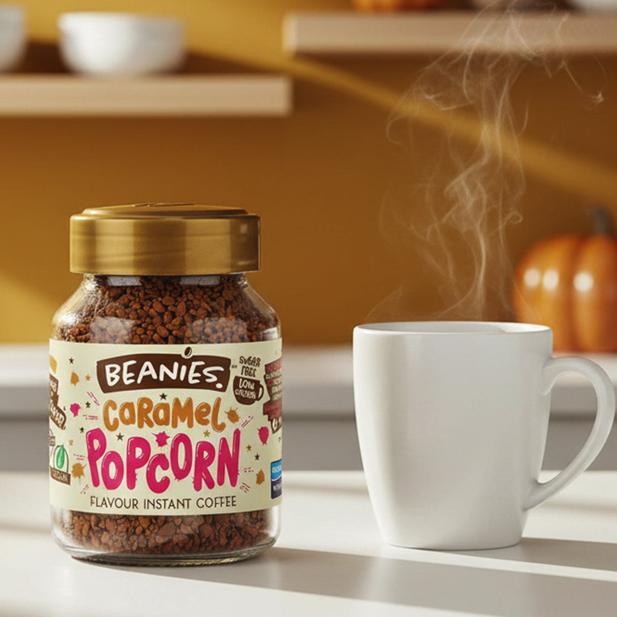 Jar of Beanies Caramel Popcorn instant coffee with a steaming white mug on a kitchen counter.