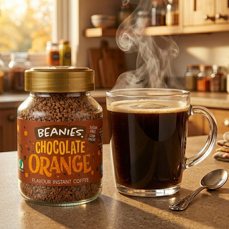 Jar of Beanies Chocolate Orange instant coffee and a steaming cup on a kitchen counter.