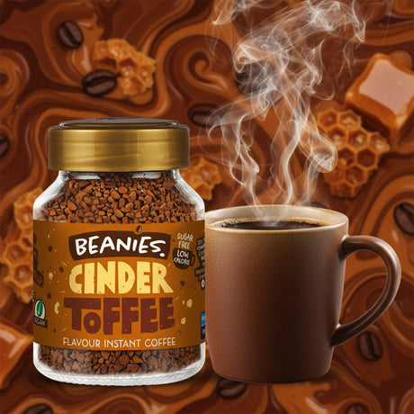 Jar of Beanies Cinder Toffee instant coffee with a steaming cup on an orange background