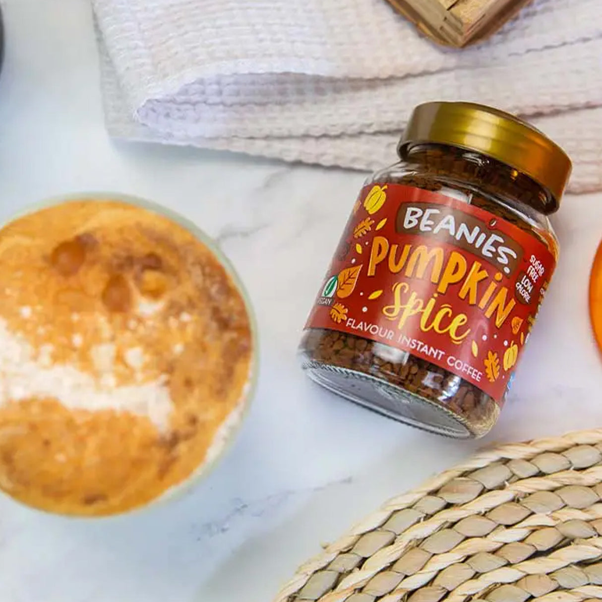 Jar of Beanies Pumpkin Spice instant coffee on a marble surface with a blurred background
