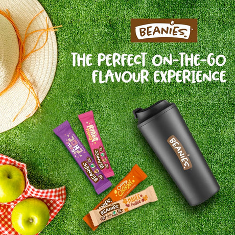Beanies snack bars and tumbler on a grassy background with promotional text.