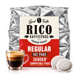 A package of Good Taste RICO Kaffepads Regular Compatible Pads, shown with a glass of espresso and two coffee pods in front of a white background.