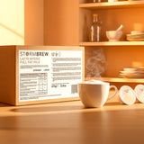 Box of Stormbrew Latte Intero Full Fat Milk on a wooden surface with a steaming cup of coffee in the foreground.