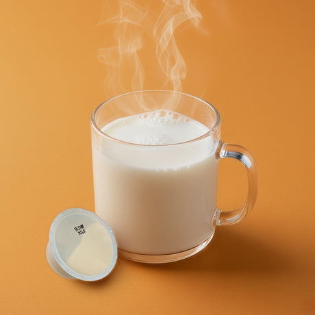 Glass mug with steaming hot beverage and a container of powder on an orange background