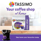 Tassimo coffee pod packaging with a Tassimo coffee machine on a wooden surface.
