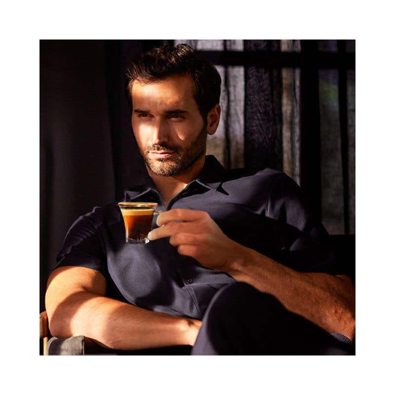 A man holding a cup of espresso