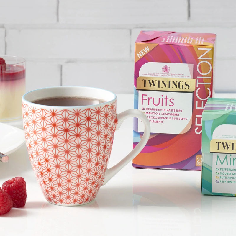A cup of tea next to a box of Twinings Fruit Selection 20s Tea Bags